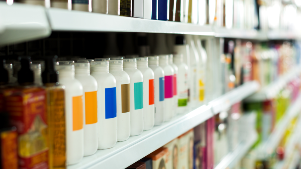 white plastic bottles with different colours on them lined up on a store shelf