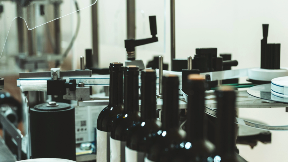 bottles lined up on a labelling machine